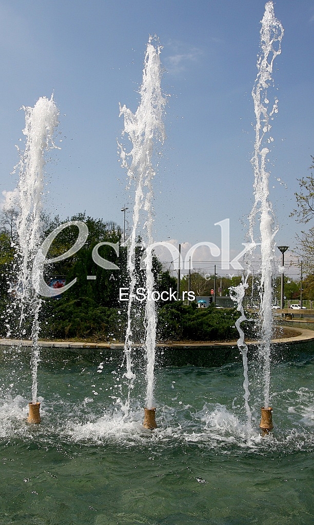 Fountain drops of pure brilliant water against a blue clear sky