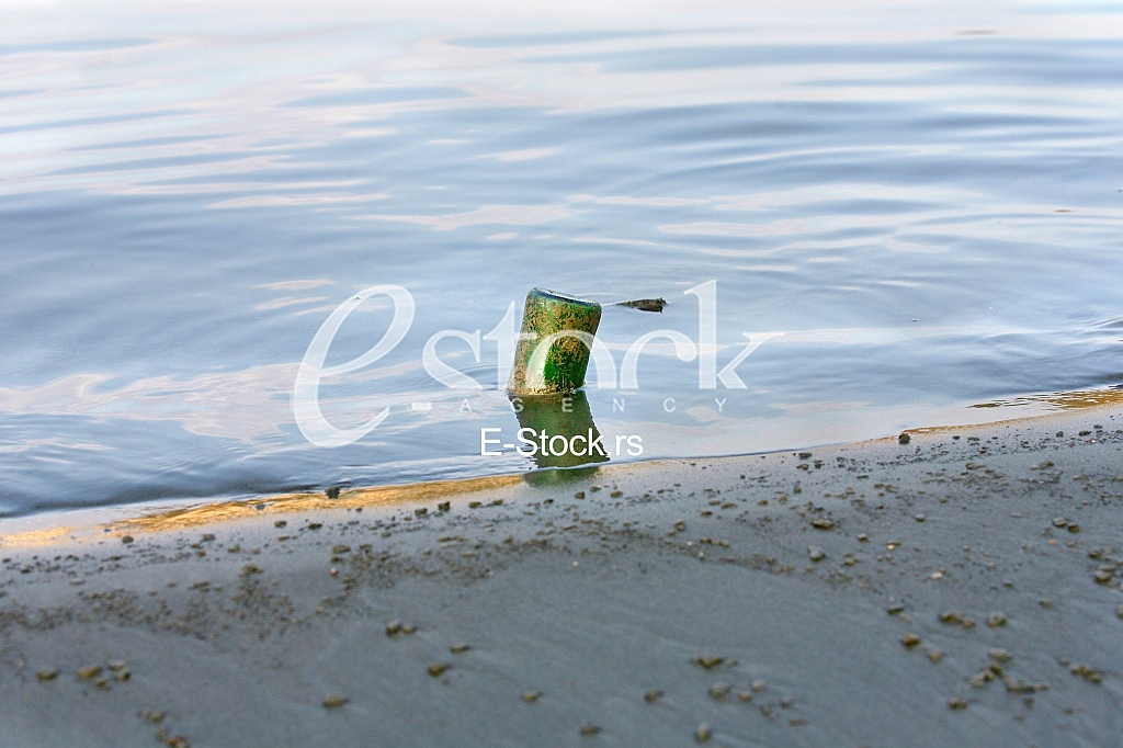Single green old bottle in the deep river water Single green old bottle in the deep river water