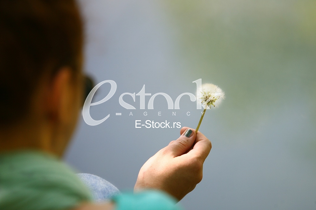 Girl with Spring dandelion on green water natural background
