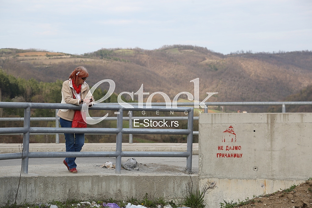 Womane looking graphite of flooding Monastery Valjevska Gracanica in lake