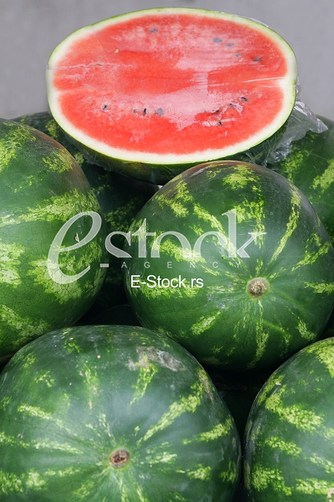 Many big sweet green watermelons and one cut watermelon background on the street market