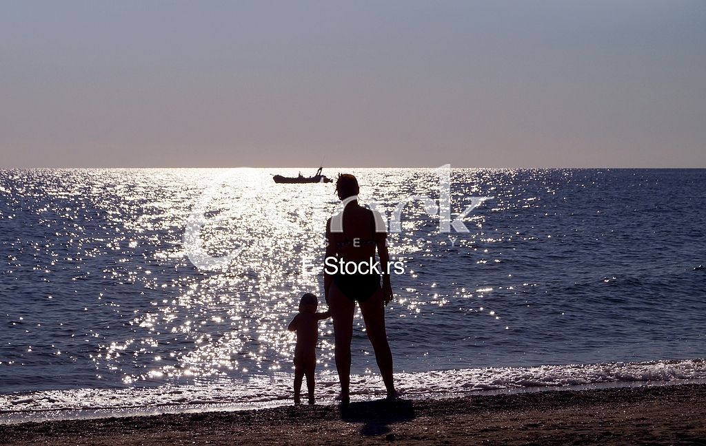 Woman with little boy at the sunset