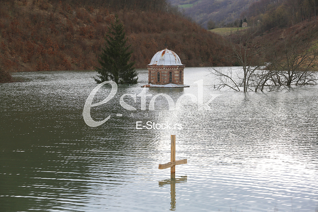 Wooden cross near flooding Monastery Valjevska Gracanica in lake
