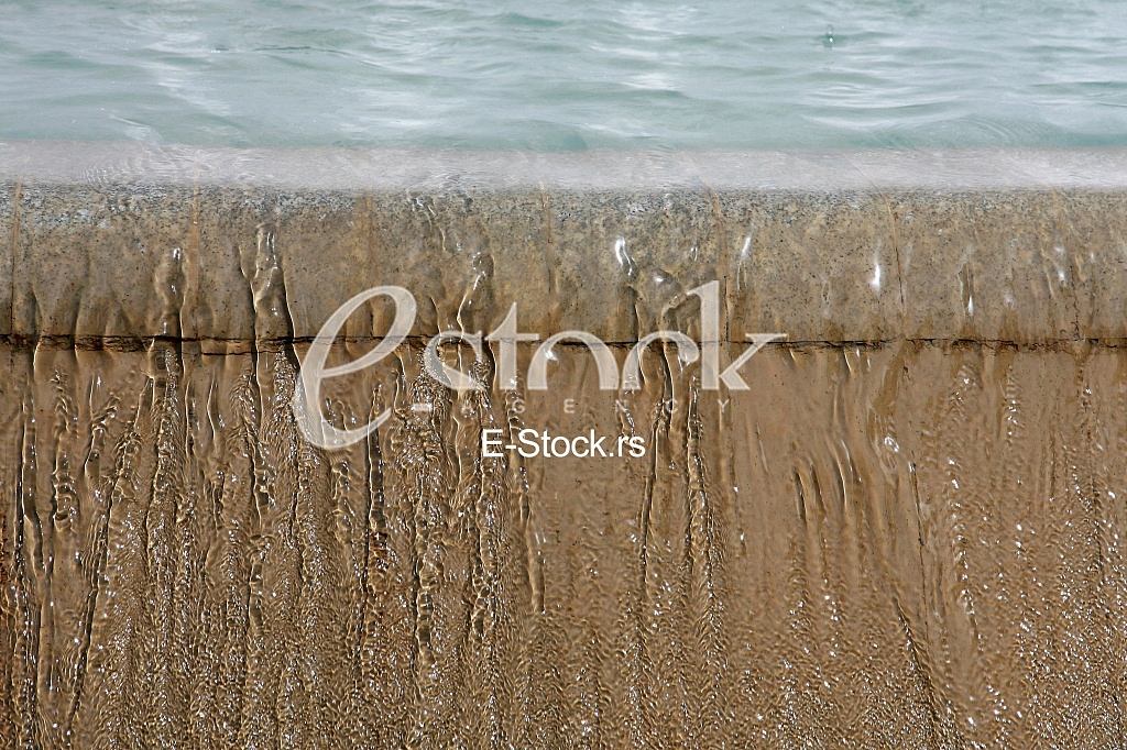 Fountain drops of pure brilliant water brown background