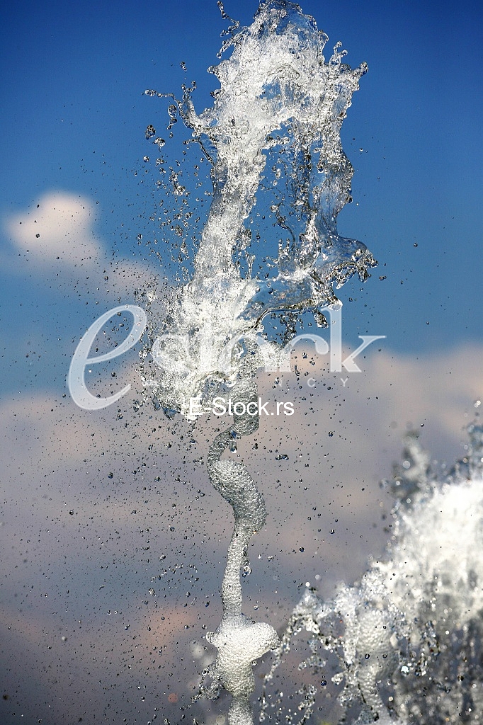 Fountain drops of pure brilliant water against a blue clear sky