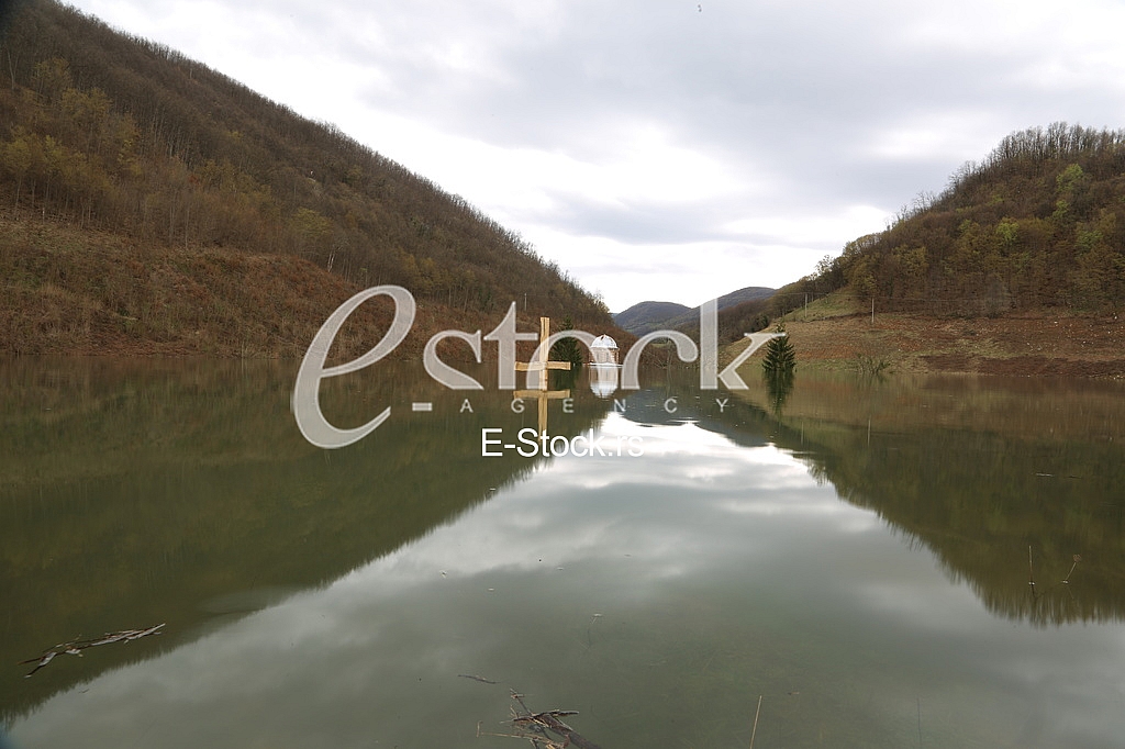 Wooden cross near flooding Monastery Valjevska Gracanica in lake