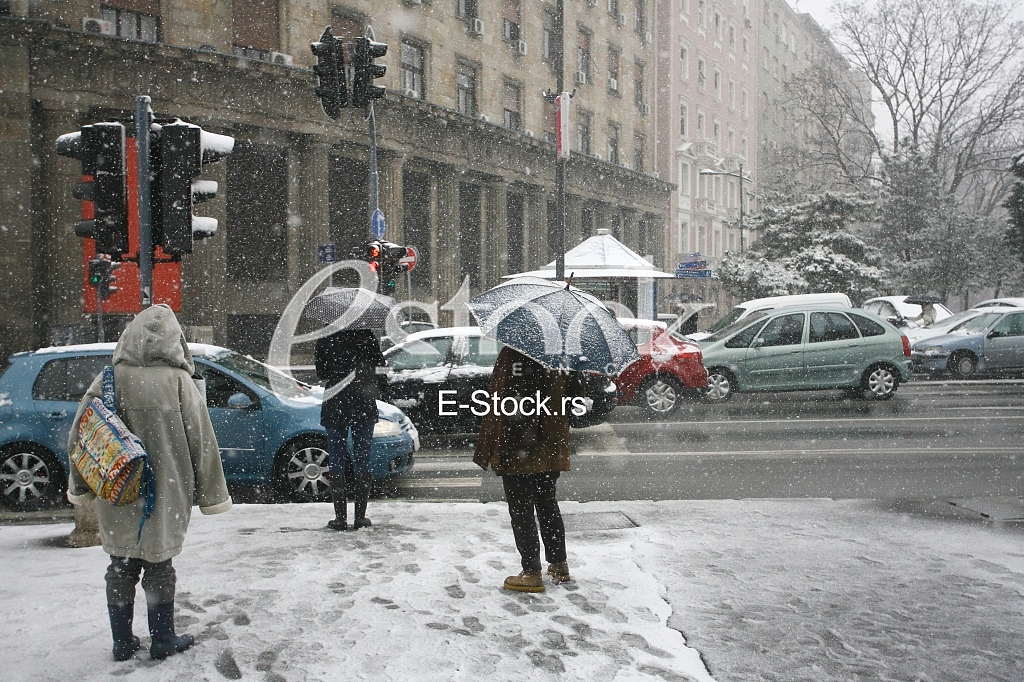 People with umbrella during snow storm car with pedestrian
