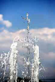 Fountain drops of pure brilliant water against a blue clear sky