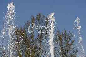 Fountain drops of pure brilliant water against a blue clear sky