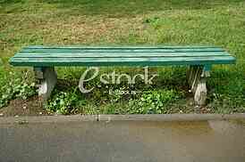 green wooden park bench at a park