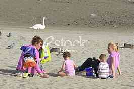 Mothers with kids on the beach strand enjoy the Spring sunny day
