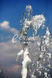 Fountain drops of pure brilliant water against a blue clear sky