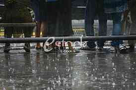 urban people waiting on the bus station and street on the rain
