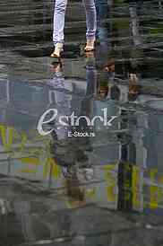 woman reflection in the water after the rain