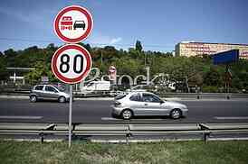 Traffic Sign 80 per hour with no overtaking and traffic on the road