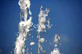 Fountain drops of pure brilliant water against a blue clear sky