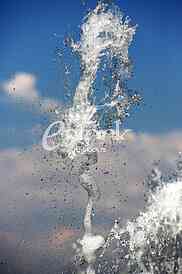 Fountain drops of pure brilliant water against a blue clear sky