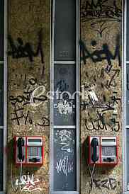call box, two telephones on the wall covered with graffiti