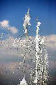 Fountain drops of pure brilliant water against a blue clear sky