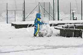 Joyful boy sculpts a snowman in park
