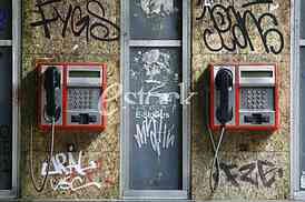 call box, two telephones on the wall covered with graffiti